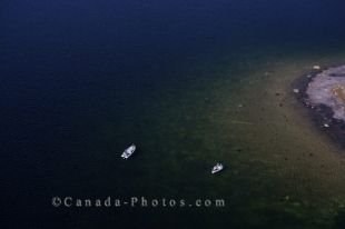 An aerial view of a couple of fishing boats resting close to the water's edge near Charlottetown in Southern Labrador, Canada.