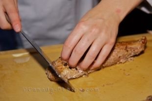 A gourmet chef is in the midst of the preparation of some meat which will be served to the guests at a fishing lodge in the wilderness of Southern Labrador.