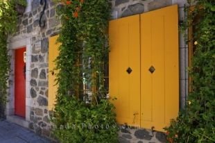 Wooden shutter windows protect the glass on this old stone building in Quartier Petite Champlain in Old Quebec in Quebec City, Canada.